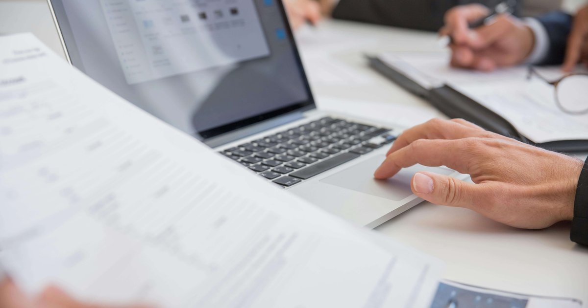 Laptop and documents representing debt review process South Africa