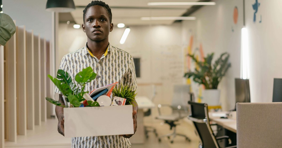 Man carrying office belongings box after retrenchment South Africa